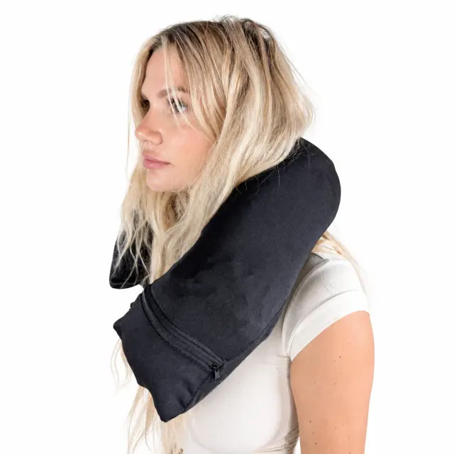 A woman wearing a long stuffable travel pillow that hangs down onto her chest